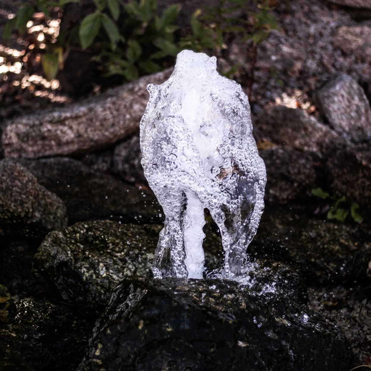 detail proudící vody v kamenném zahradním vodním prvku